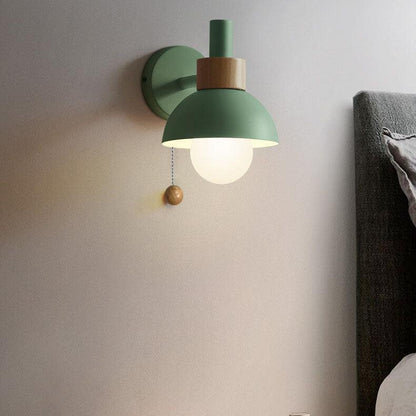 Green Macaron globe wall light beside a bed
