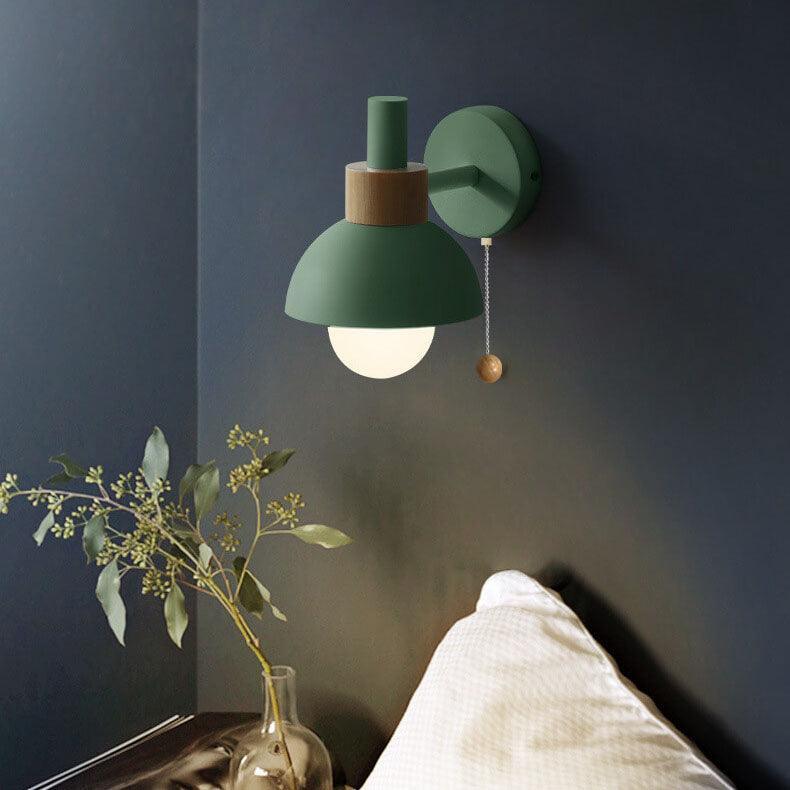 Green wall sconce with glowing glass globe