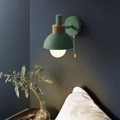 Green wall sconce with glowing glass globe