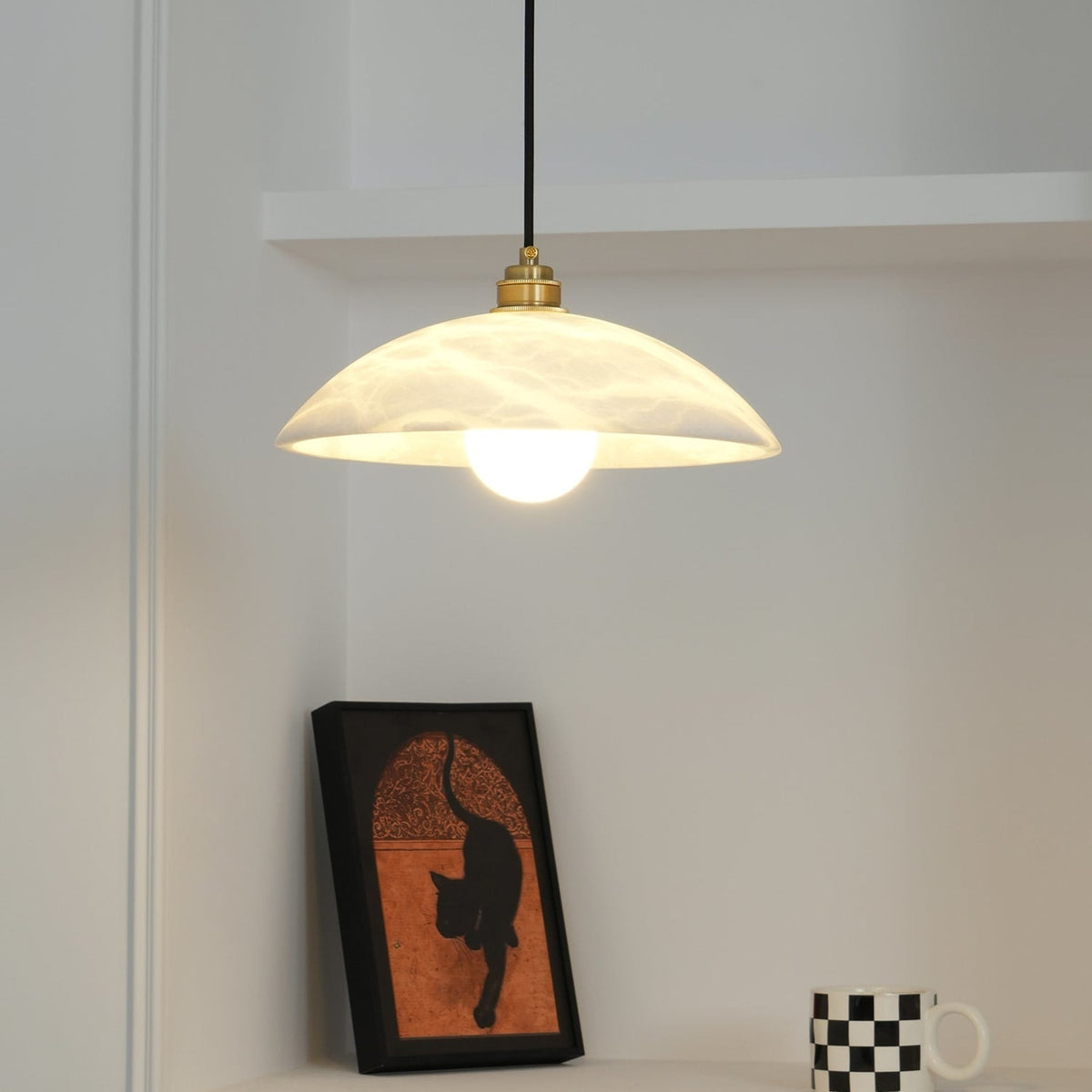 Warmly lit marble pendant near framed artwork
