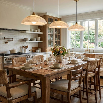 Three illuminated marble pendants above a dining table