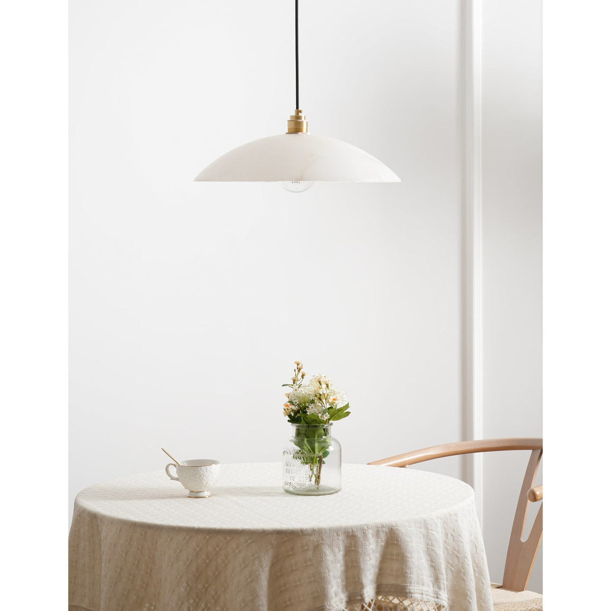 White marble pendant above a cloth-covered table