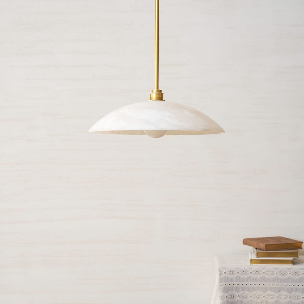 Marble dome pendant with a metallic suspension rod