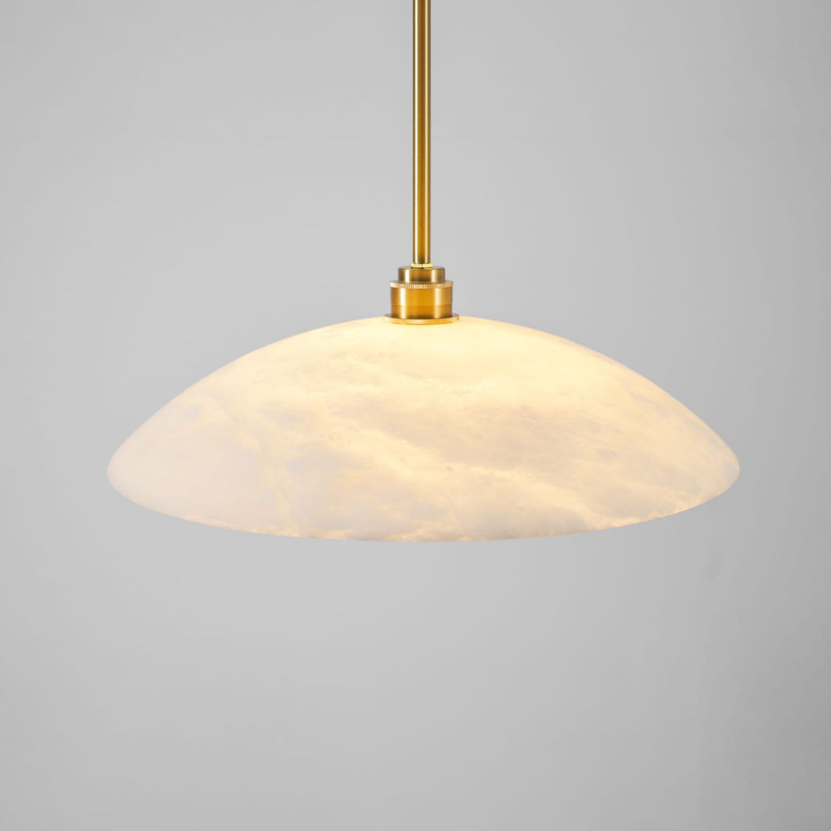 Marble dome shade with warm light through the stone