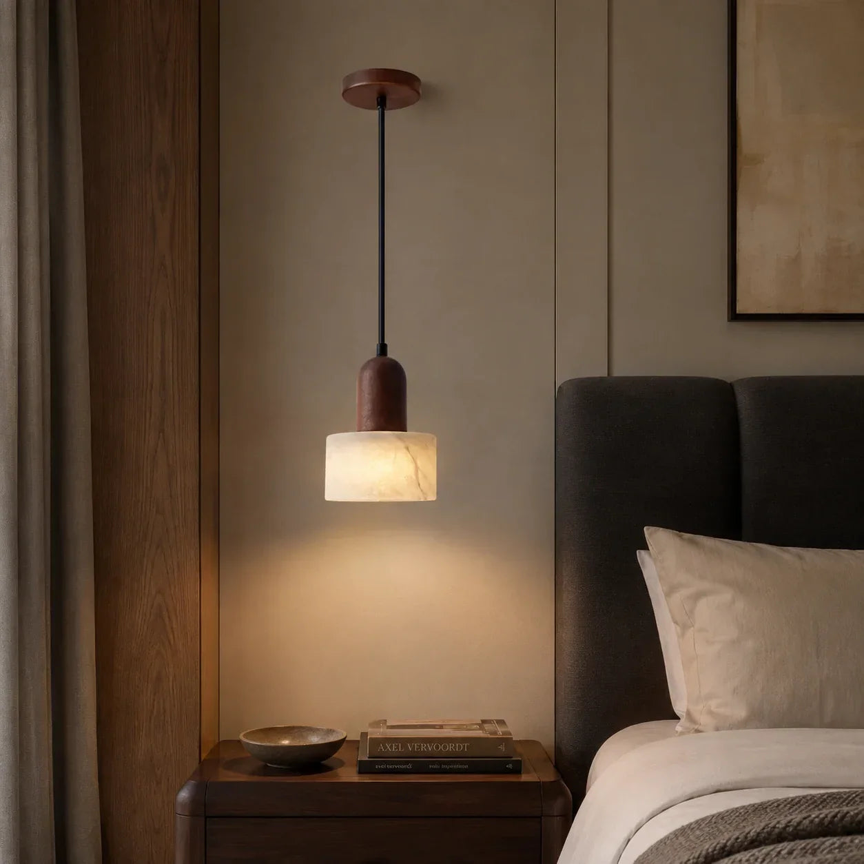 Minimalist marble pendant light with walnut wood detail hanging above a bedside table in a warm, wabi-sabi inspired bedroom interior.