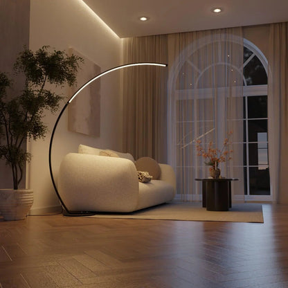 Black arc floor lamp illuminating a living room at night