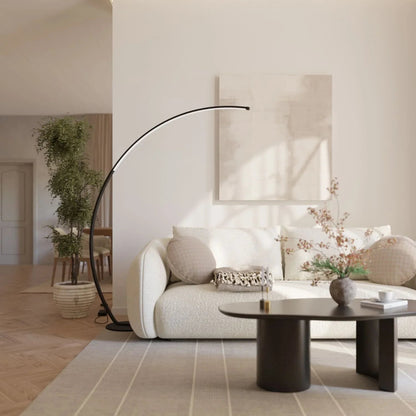 Black arc floor lamp beside a living room sofa