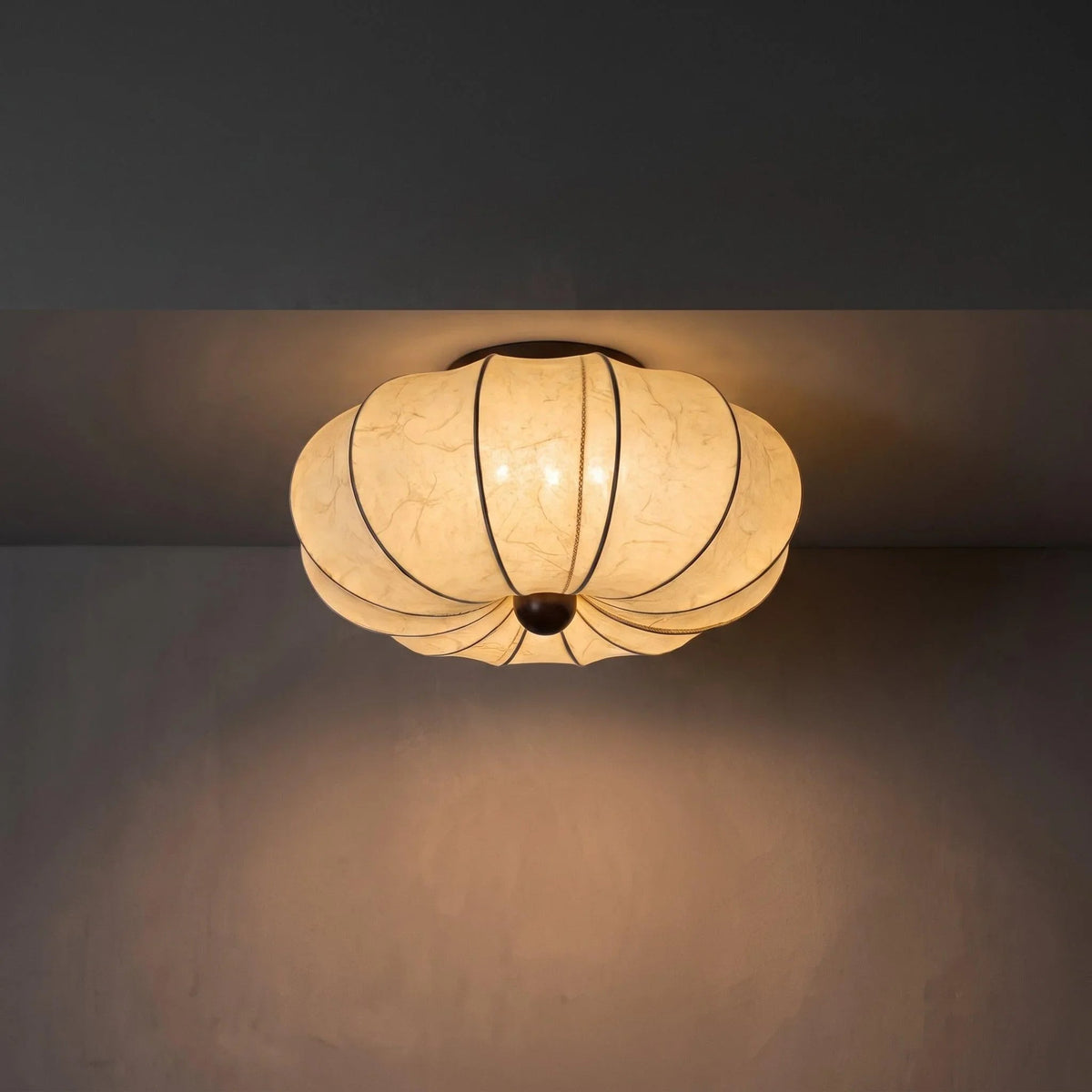 Warm glowing silk ceiling light in a dark room