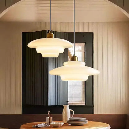 Layered glass pendant lights above a dining table