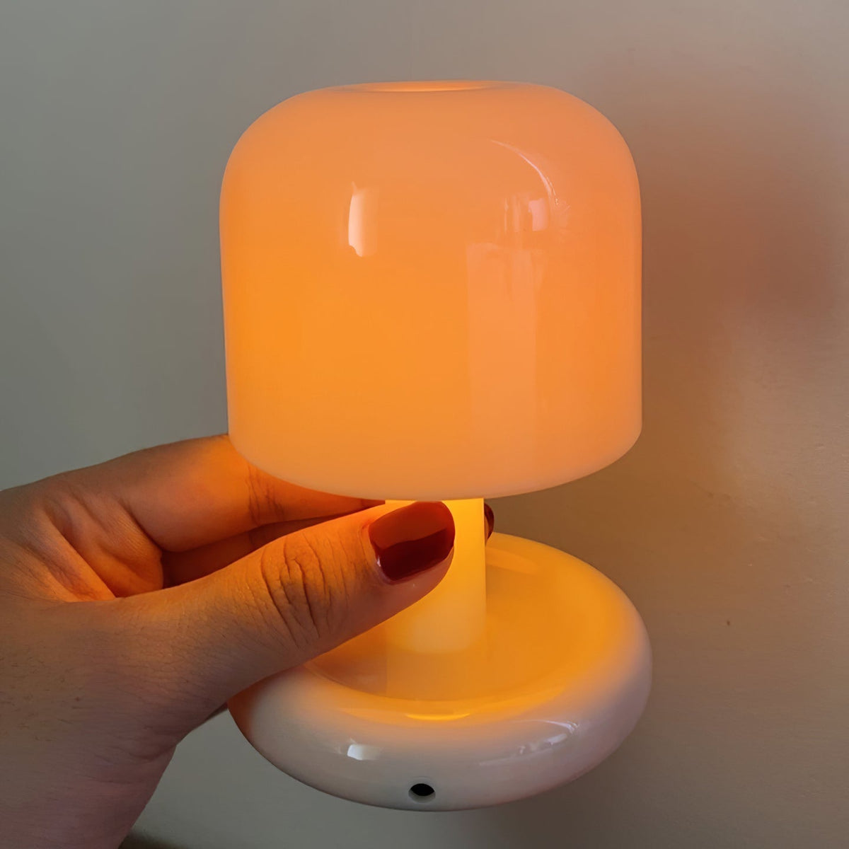 Milky white mini mushroom table lamp held in a hand