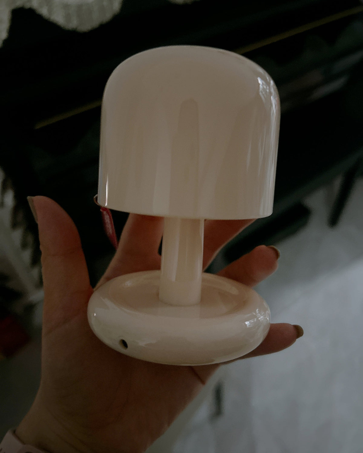 Milky white mini mushroom table lamp held in a hand