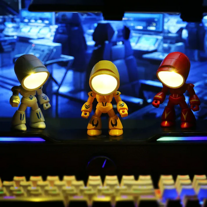 Illuminated robot table lamps beside a computer keyboard