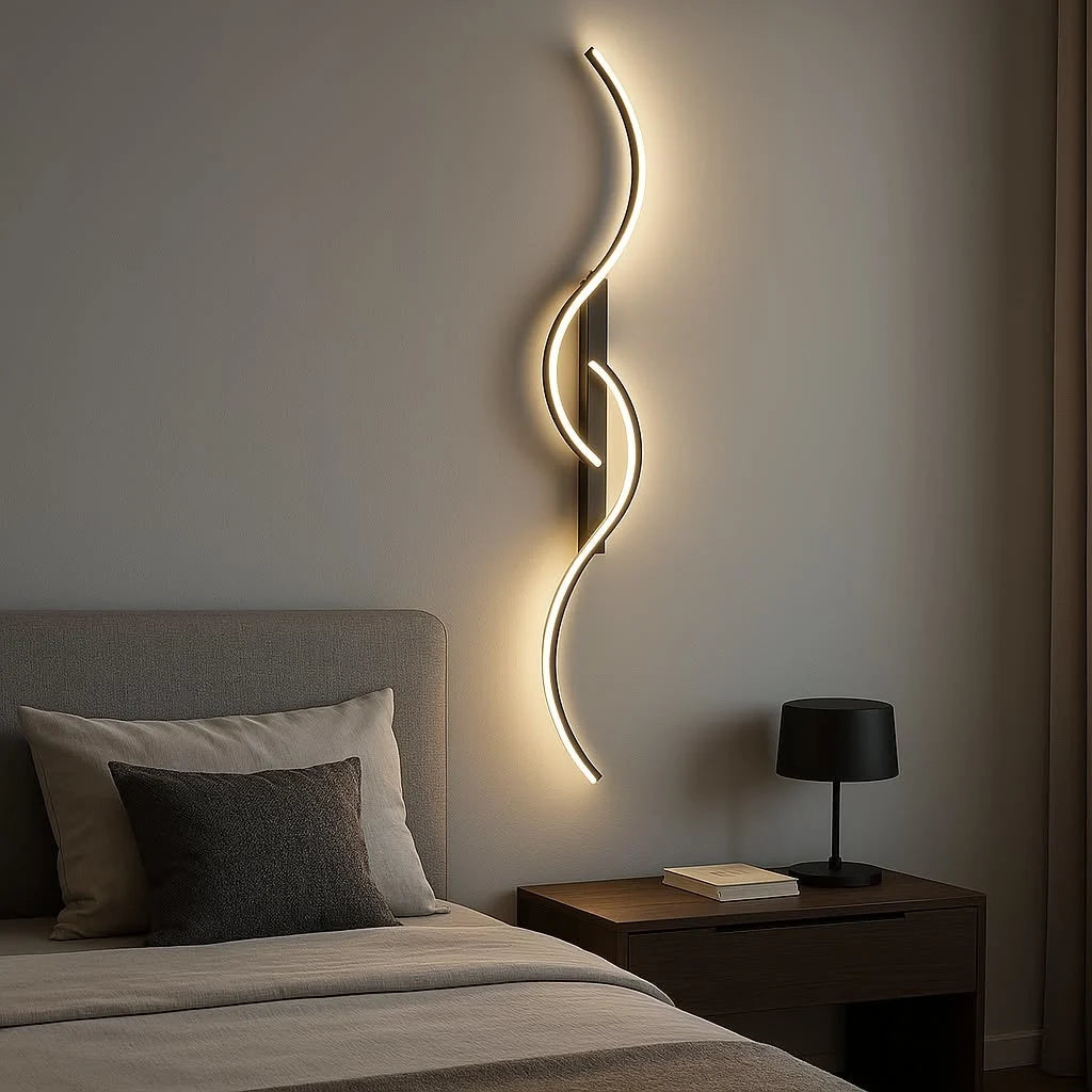 A minimalist curved LED wall light with a sleek, wave-like design mounted above a bedside table in a modern bedroom, casting a warm, ambient glow.