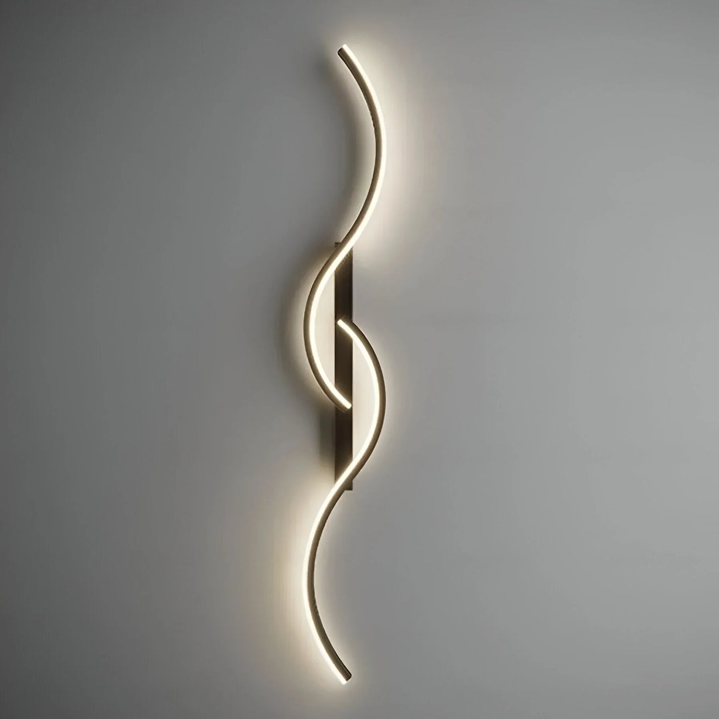 A minimalist curved LED wall light with a sleek, wave-like design mounted on a neutral grey wall, emitting a soft, warm glow for modern indoor lighting.