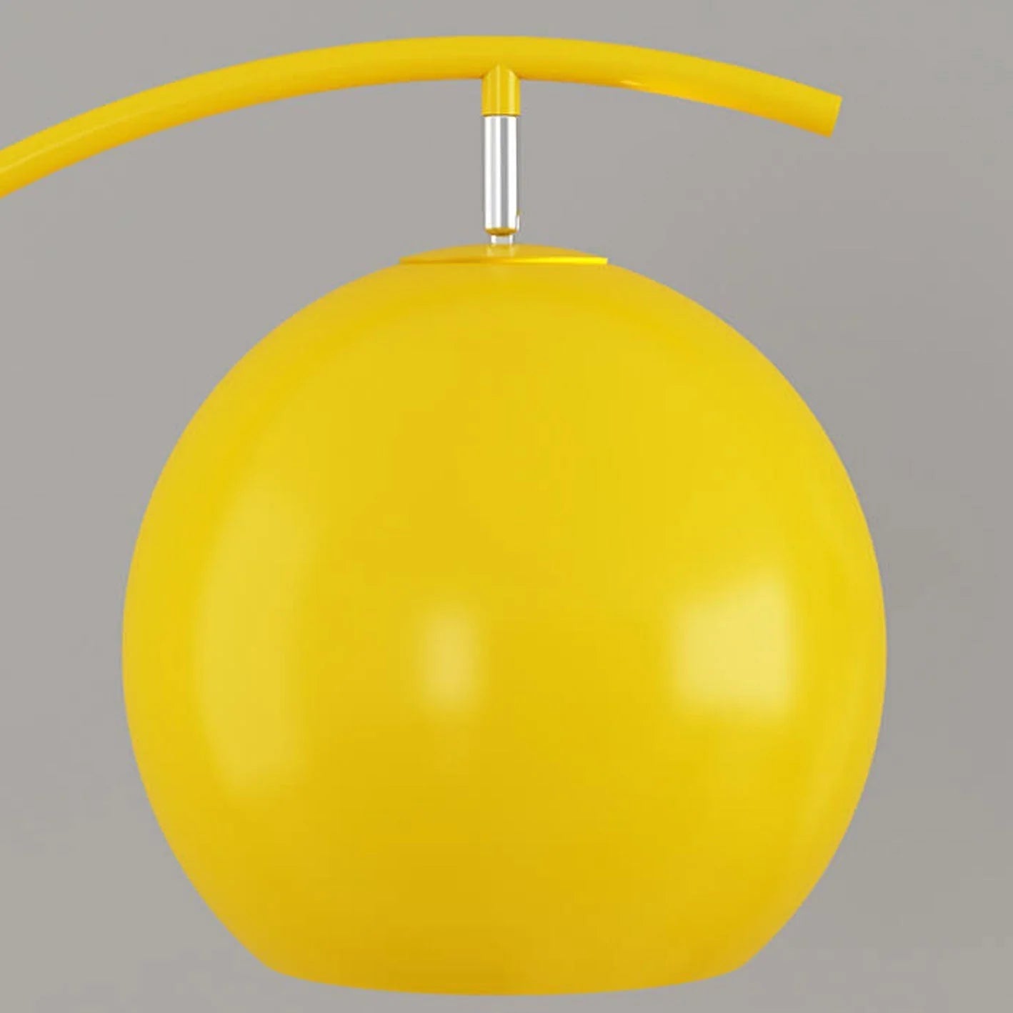 Close-up of the bright yellow spherical shade of a minimalist LED arc floor lamp, showing the adjustable silver connector and curved yellow arm.