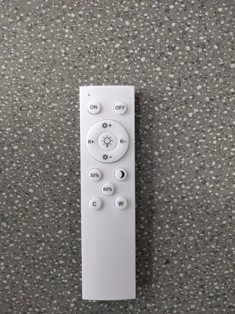 A white remote control for the Minimalist LED Floor Lamp, featuring buttons for power, brightness level, and colour temperature adjustment.