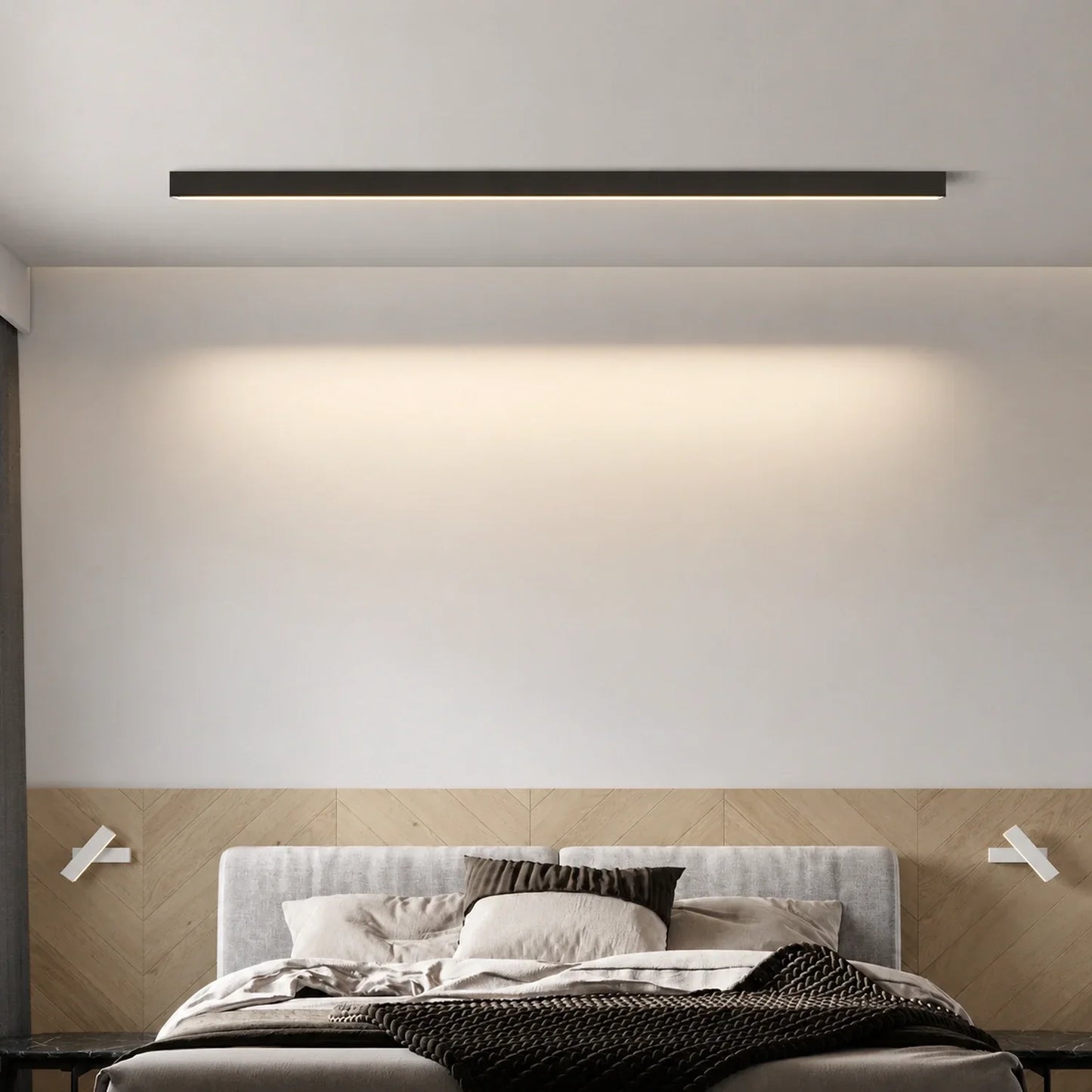 Minimalist black linear LED ceiling light mounted above a modern bedroom bed, casting a warm glow against the white wall and wooden headboard.
