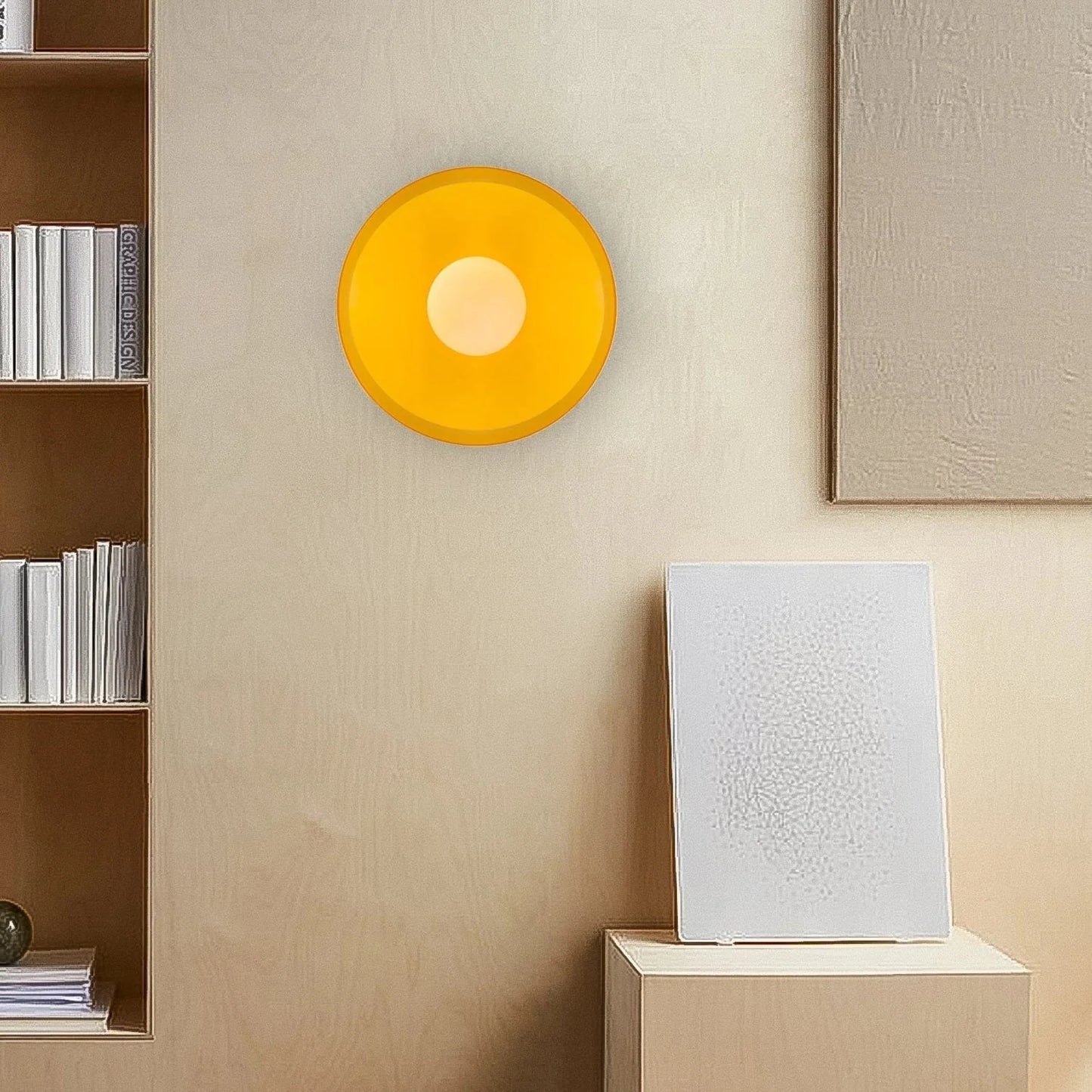 Modern Bauhaus style flush mount ceiling light with a circular yellow glass shade mounted on a neutral wall in a contemporary living space interior.