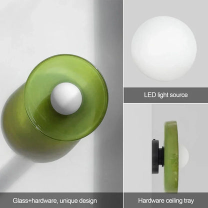 Modern Bauhaus flush mount ceiling light featuring a green glass shade, white spherical LED light source, and a black iron hardware ceiling tray.