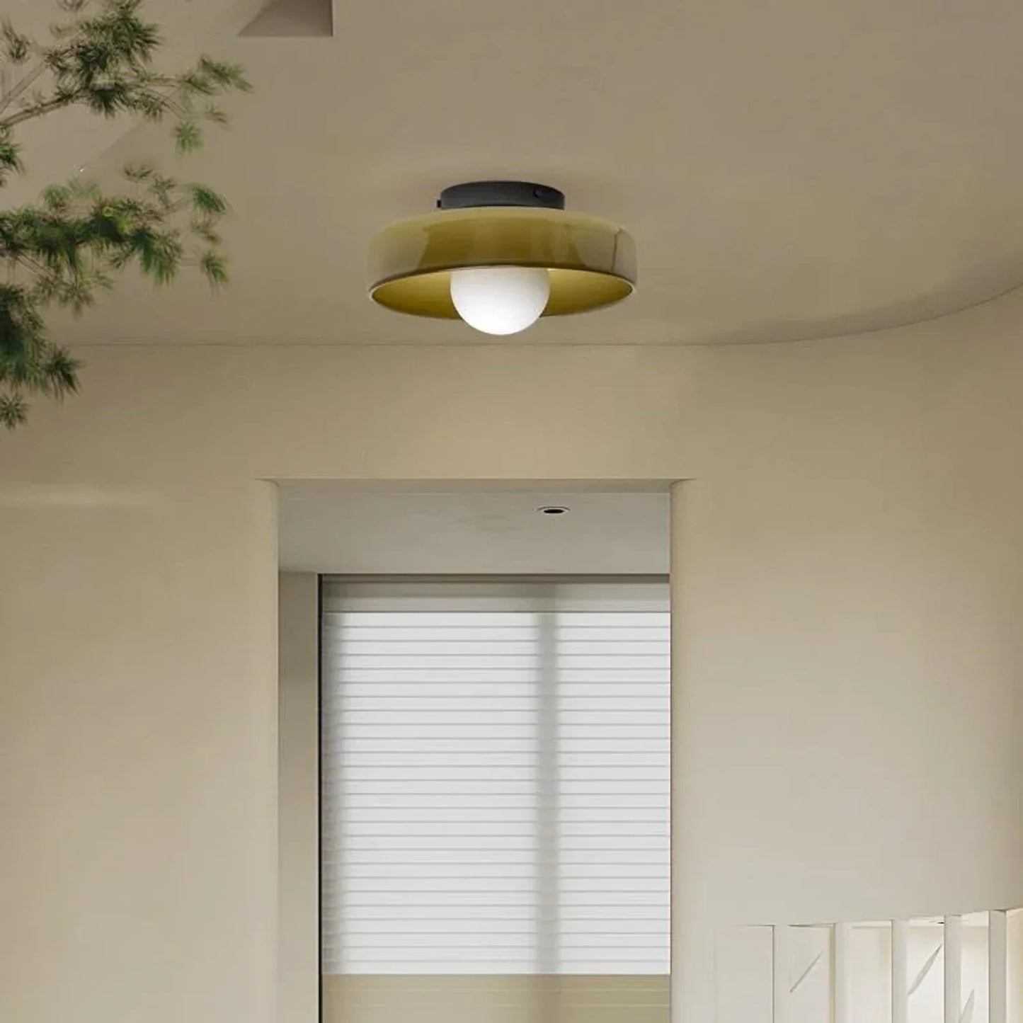 Modern Bauhaus style flush mount ceiling light with a wide olive green glass shade and a central white globe bulb, installed in a neutral interior.