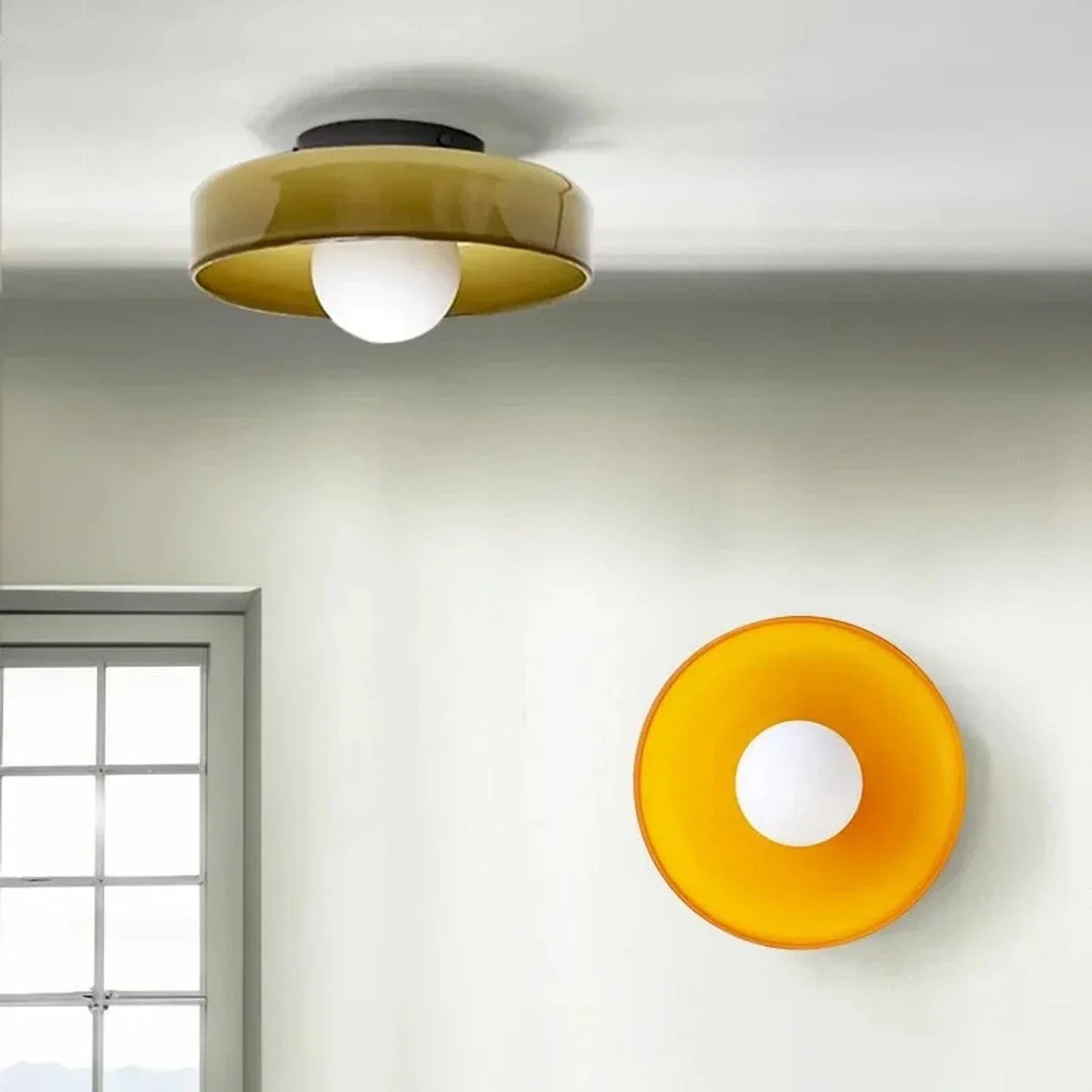 Modern Bauhaus flush mount ceiling light with a circular amber glass shade and a central white globe bulb, mounted on a white ceiling in a bright room.