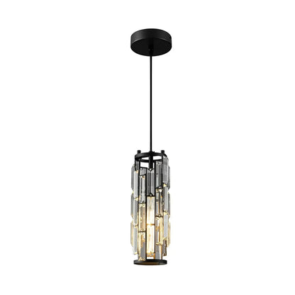 A modern cylindrical pendant light featuring clear vertical crystals set in a black frame, suspended by an adjustable cord and illuminated f