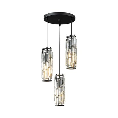 Modern 3-light crystal pendant light with a black circular ceiling plate and three staggered cylindrical crystal shades, illuminated.