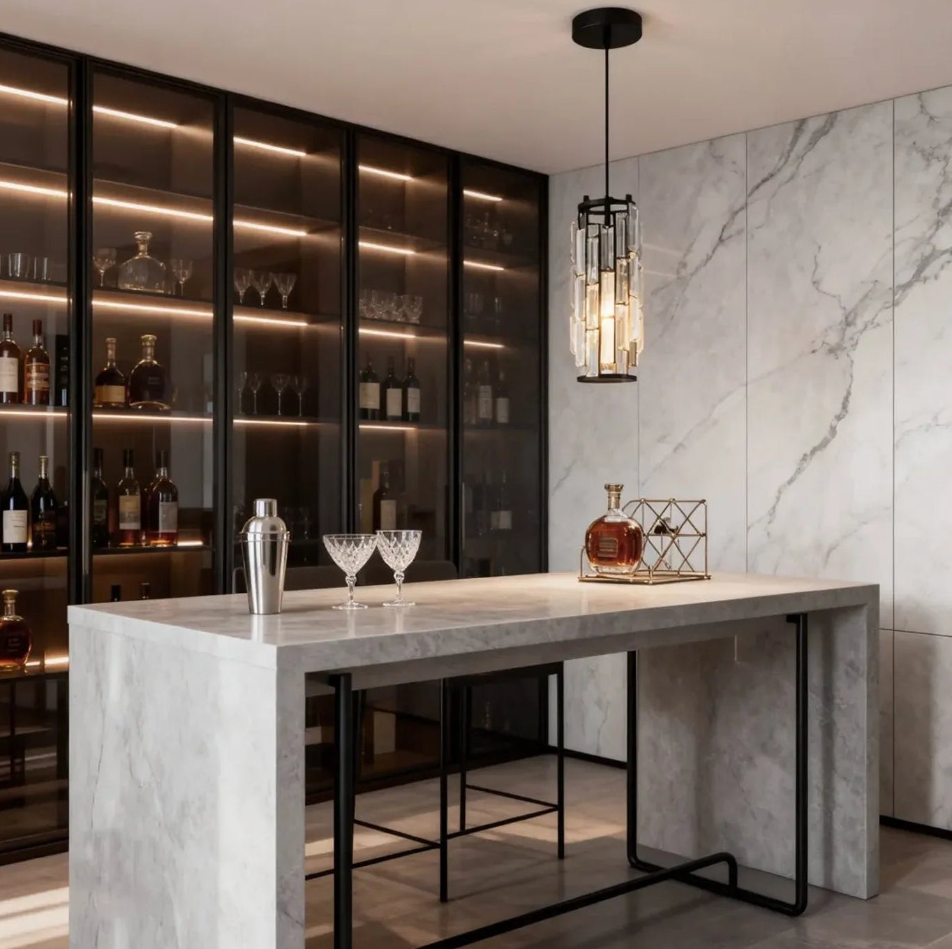 A modern crystal pendant light with a black frame suspended above a marble kitchen island in a stylish, contemporary home bar setting