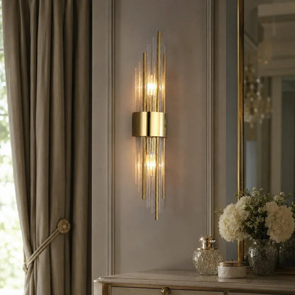 Modern gold crystal wall light with a metal frame, showing a warm white up and down light mounted on a grey panelled wall.