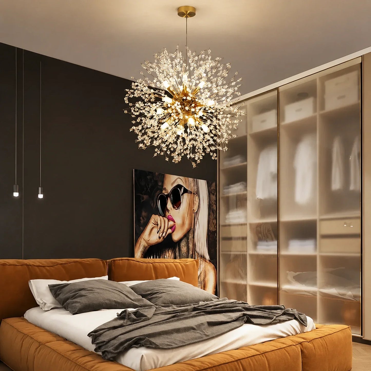 Modern dandelion LED pendant light with a spherical crystal design suspended above a contemporary bedroom with a brown upholstered bed and wardrobe.