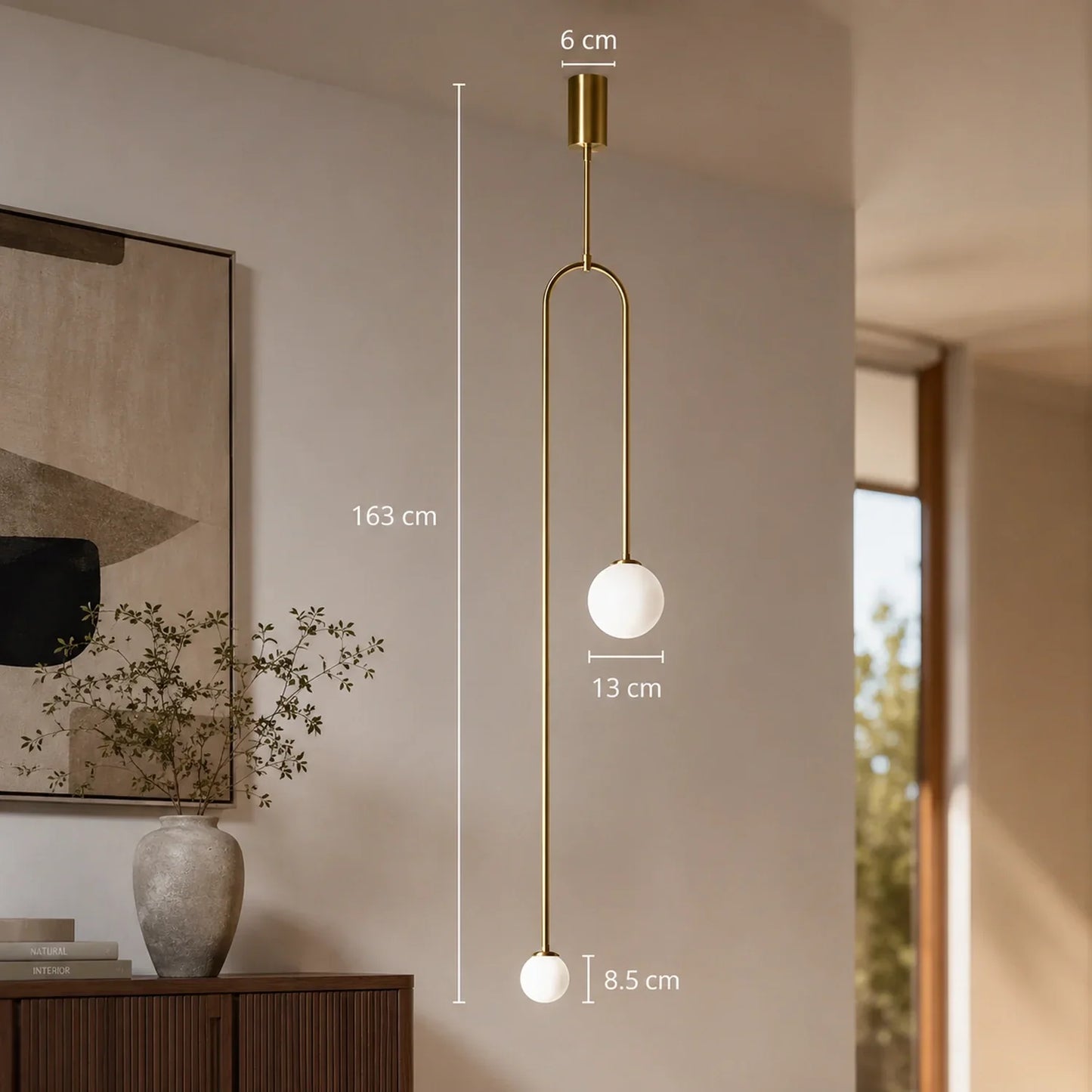 Modern large gold double globe pendant light with two white glass spheres suspended at different heights, shown with technical dimension annotations.