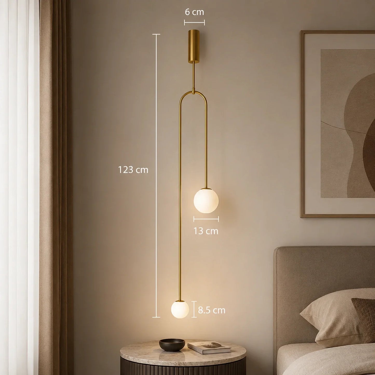 Modern gold double globe pendant light with warm illumination, featuring a minimalist design and dimensions displayed against a neutral bedroom wall.