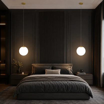 Two modern glass globe pendant lights with warm illumination hanging above bedside tables in a stylish dark grey bedroom interior.