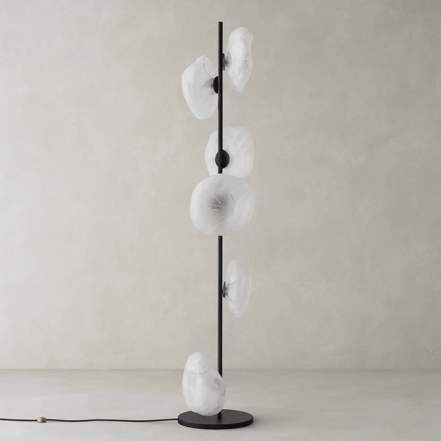 Modern floor lamp with a slim black metal stand and five organic, transparent glass shades arranged vertically, perfect for living room lighting.