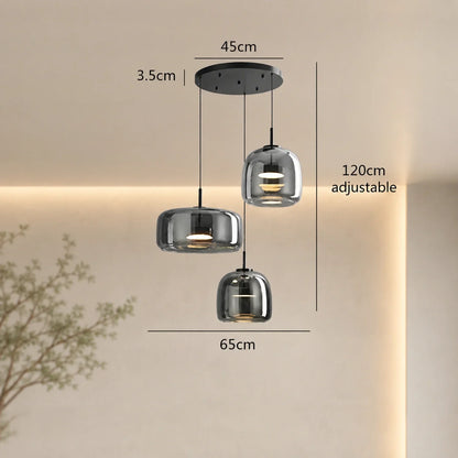 Modern round triple-head pendant light in smoky grey glass with dimensions shown, featuring three adjustable hanging lights on a black ceiling canopy.
