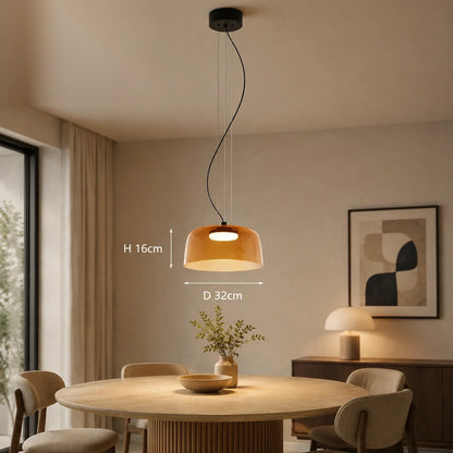 Modern orange glass pendant light with integrated LED, hanging over a round dining table, showing dimensions of 32cm diameter and 16cm height.