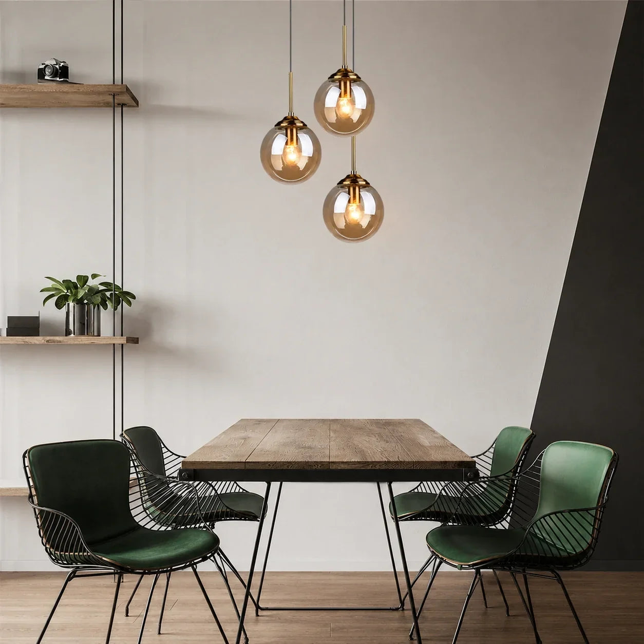 Three modern globe glass pendant lights with brass fittings hanging above a wooden dining table in a contemporary kitchen or dining room setting.