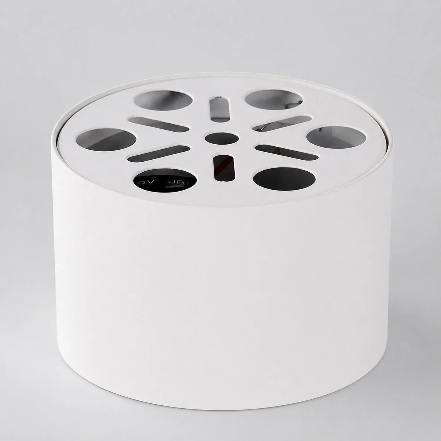 White cylindrical surface-mounted aluminium LED ceiling light, showing the top mounting plate with circular and slotted ventilation cutouts.