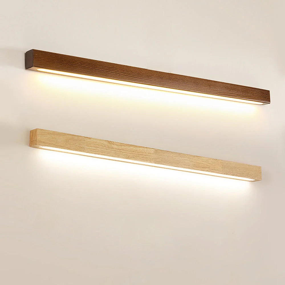 Two modern linear LED wall lights with dimmable warm glow, featuring one dark brown and one light wood finish mounted horizontally on a plain wall.