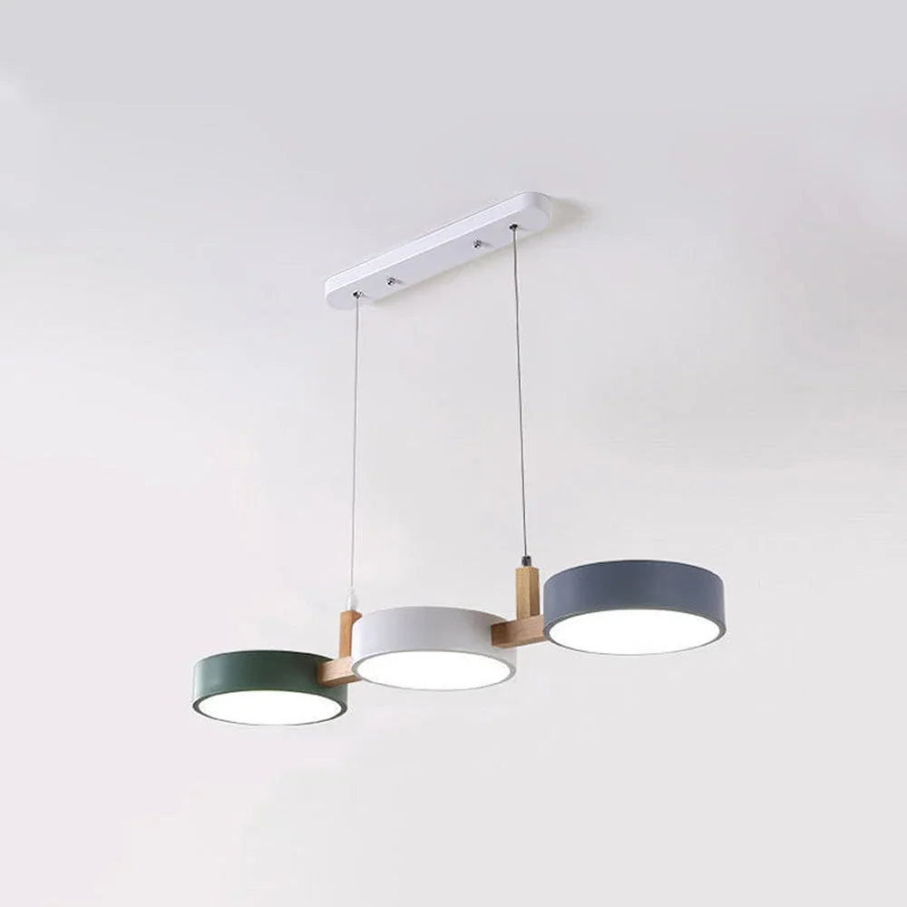 Modern 3-light pendant featuring circular green, white and grey shades connected by natural wood accents, suspended from a white ceiling canopy.