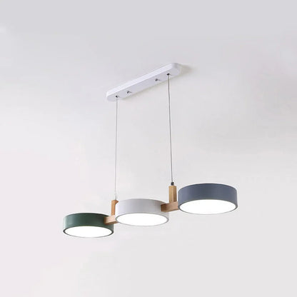 Modern 3-light pendant featuring circular green, white and grey shades connected by natural wood accents, suspended from a white ceiling canopy.