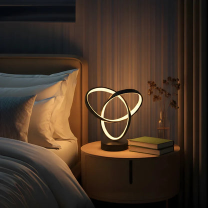 Three-ring LED lamp beside a bed
