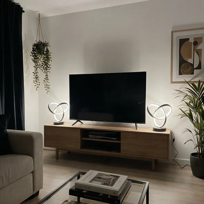 Spiral desk lamps beside a television with cool light