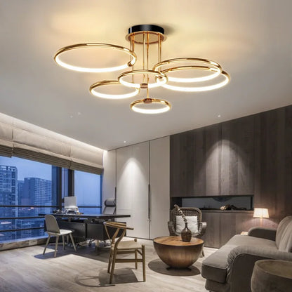 Gold six-ring LED ceiling light above a living area