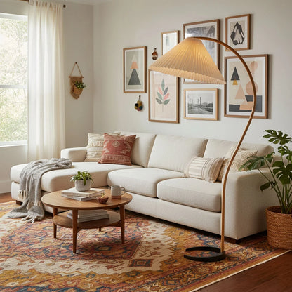 Nordic beech wood floor lamp with a pleated shade illuminating a cosy living room featuring a cream sofa, patterned rug and gallery wall decor.