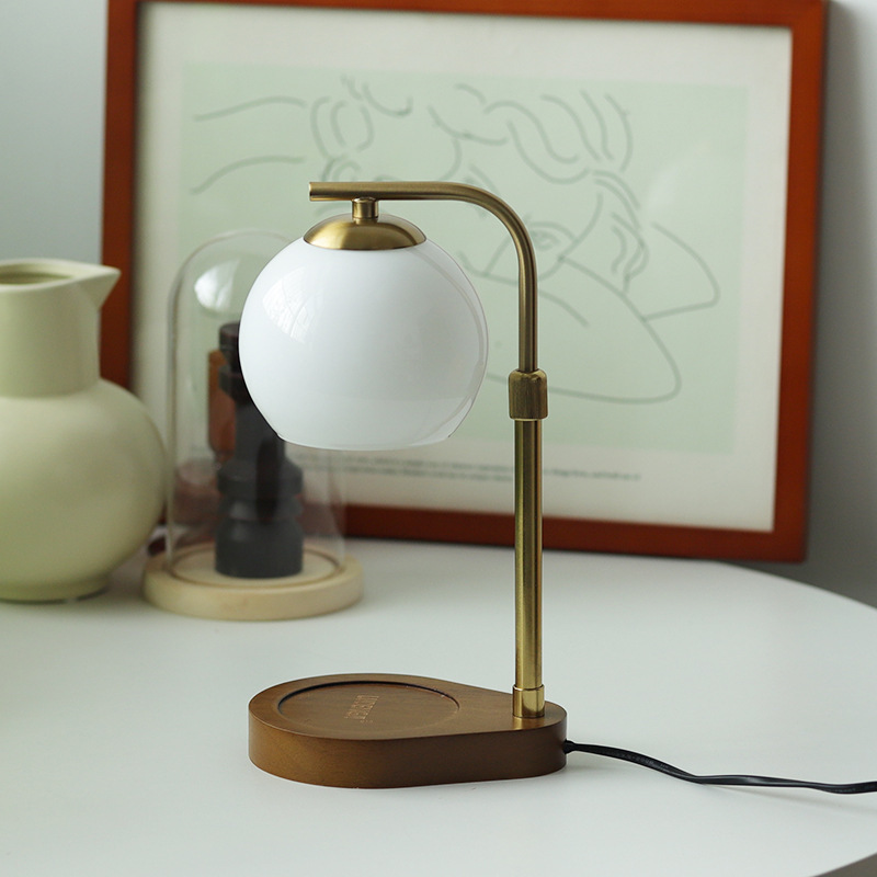 White globe candle warmer with a circular wooden base