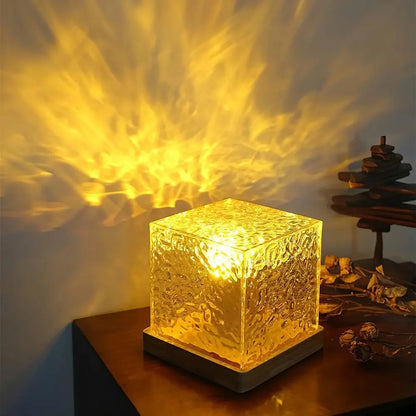 Acrylic cube lamp on a wood base casting golden light