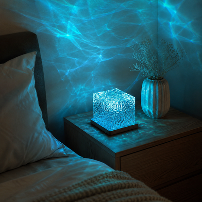 Ocean lamp creating blue ripple patterns beside a bed