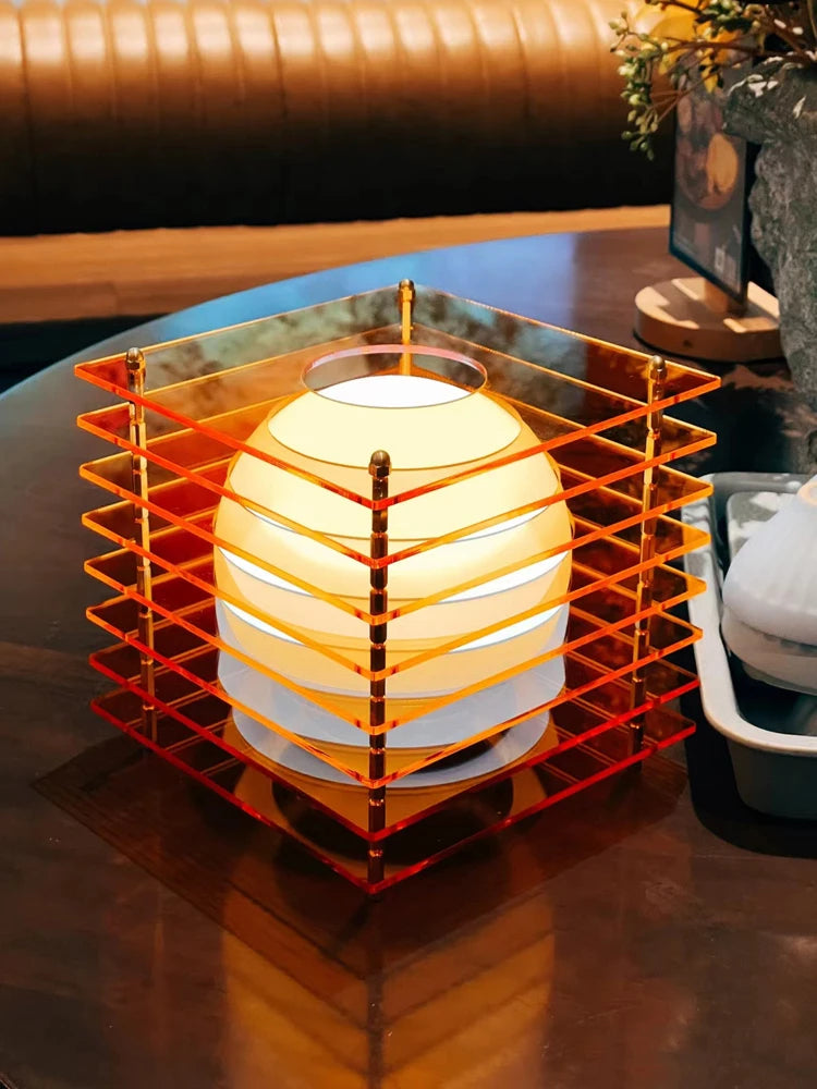 Orange acrylic cube rechargeable LED table lamp in an interior setting