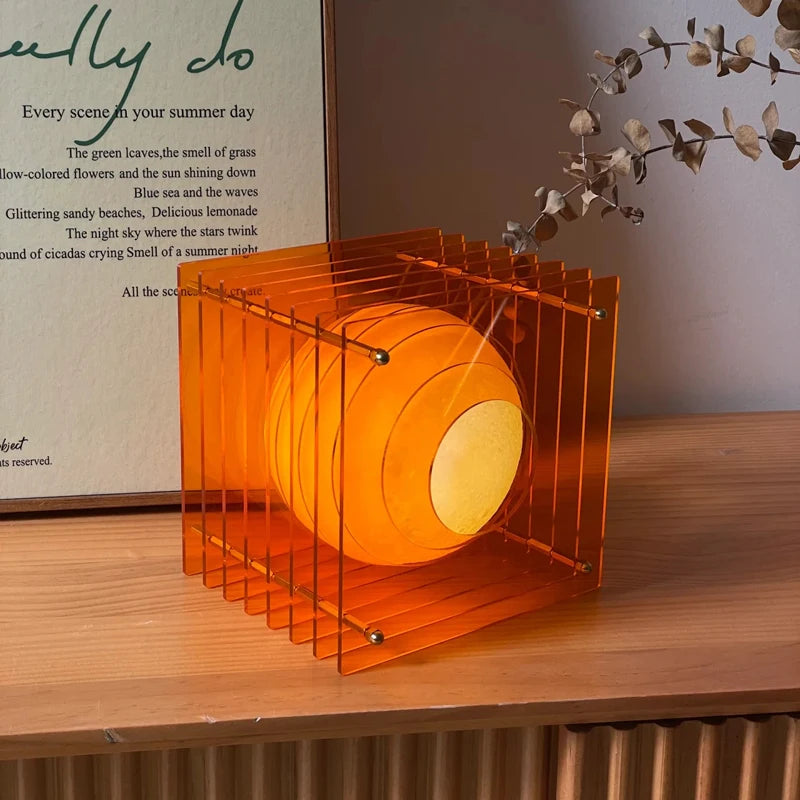 Orange rechargeable LED cube table lamp on a table